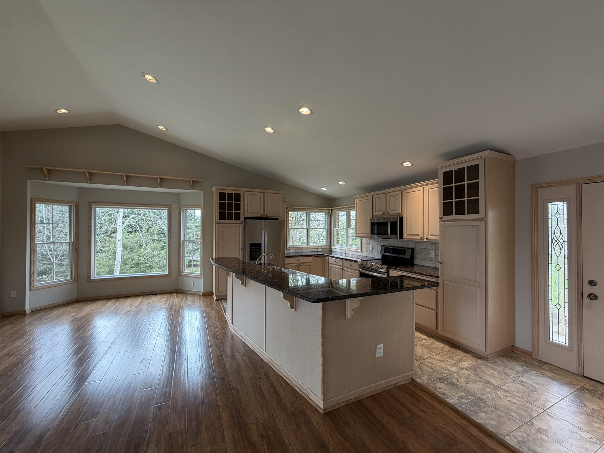 Custom kitchen with granite island and stainless appliances